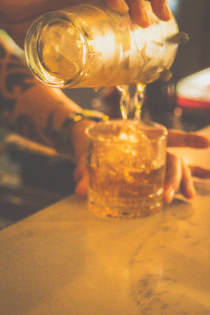 bartender making a cocktail made from Whisky, Home-madeInfused Rosemary Syrup, Bitters served in a...