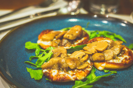 CHERRY SMOKED  CHEESE WITH PORCINI MUSHROOM Scarmoza pan-seared.  Served with arugulaの写真素材