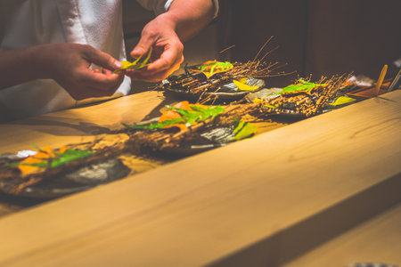 a japanese chef's hands preparing dishes in a kaiseki omakase restaurant counter
