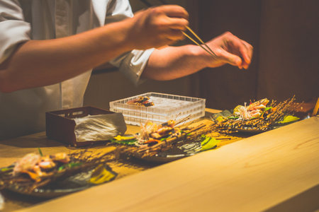 a japanese chef's hands preparing dishes in a kaiseki omakase restaurant counterの写真素材