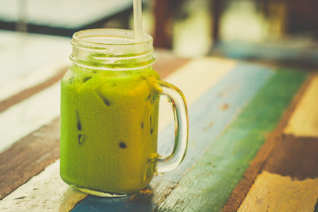 Thai Green Milk Tea served with ice and a straw in a glass mugの写真素材