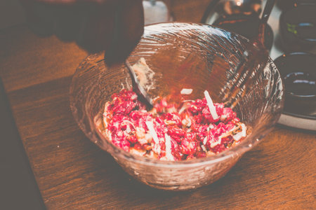 a pair of chef hands preparing Beef tartare with Sbrinz cheese and rucola saladの写真素材