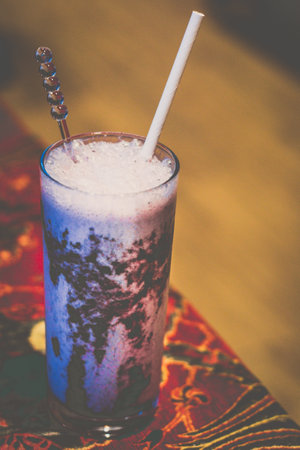 blueberry in a glass with a straw on a tableの写真素材