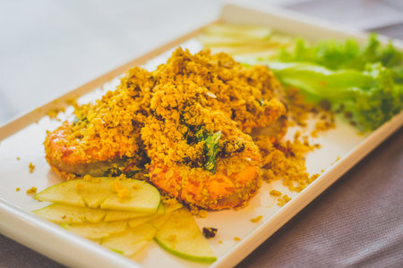 Crispy Cereal Prawn with fried basil leaves and apple slices on the sideの写真素材