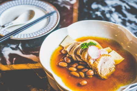 BRAISED DUCK with tofu slices and braised peanuts in a white dishの写真素材