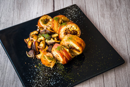 chicken roulade with sauteed mushrooms served on a black platterの写真素材