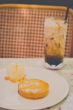 Lemon Tart Served with vanilla ice cream on a white plateの写真素材