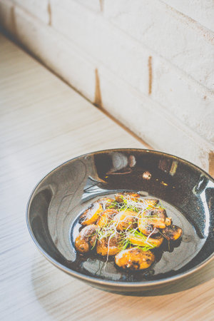 SautÃ©ed Mushrooms with butter and herb served in a black dish