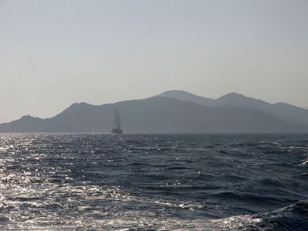 A traditional sailing boat covered by the mists of the aegean sea.の写真素材