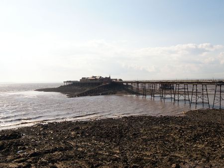 An old abandoned pier in the dirt filled sea.の写真素材