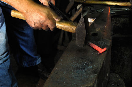 Blacksmith forges iron in the forgeの写真素材