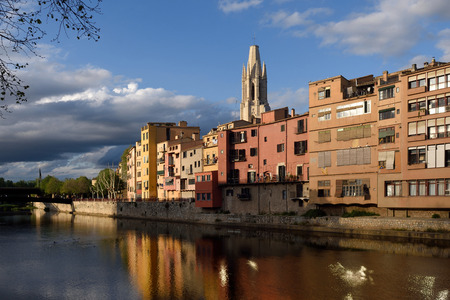 Colorful houses on the river Onyar and church of Sant Feliu, Girona, Catalonia, Spainの写真素材