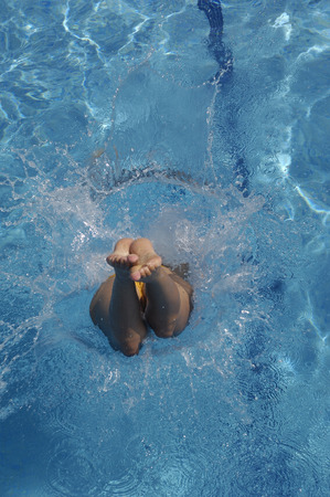 girl jumping in the pool a summer dayの写真素材