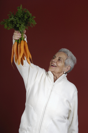 Senior woman with carrotsの写真素材