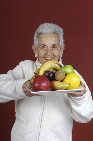 senior woman with fruitの写真素材