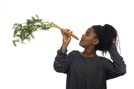 Teenage girl playing with a carrot,の写真素材