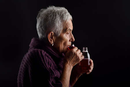 Old woman taking syrupの写真素材