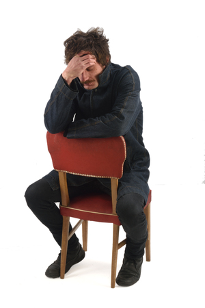 full portrait of a man sitting on a chairの写真素材