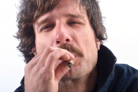 Portrait of a man smoking liar tobacco on white backgroundの写真素材