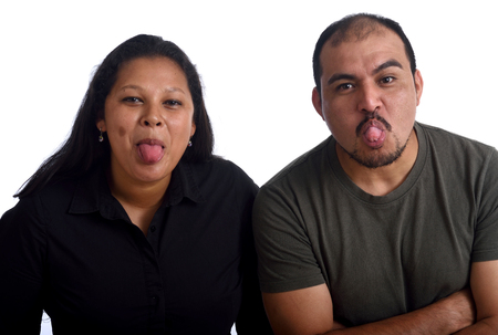 Couple sticking out tongue on white backgroundの写真素材