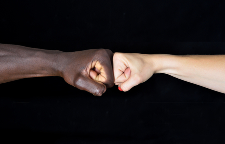 A hands of black man and white woman on black backgroundの写真素材