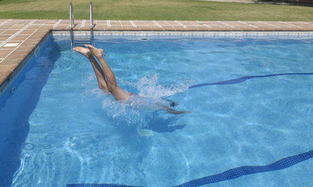 Woman jumping in the poolの写真素材