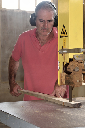 carpenter cutting wood on a band saw