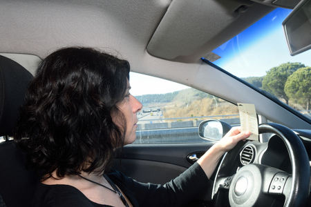 Woman driving a car with tiket toolの写真素材