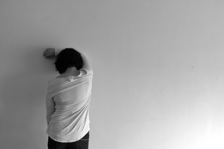 Woman from behind in front of a wallの写真素材