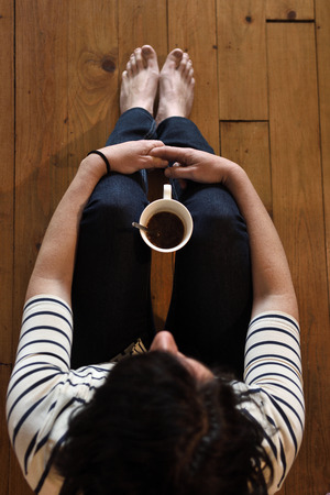 woman sitting on the wooden floorの写真素材