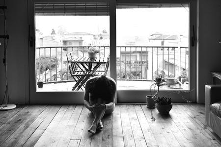 a sad woman naked in her houseの写真素材
