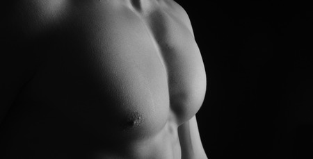 naked breast of a man on black backgroundの写真素材