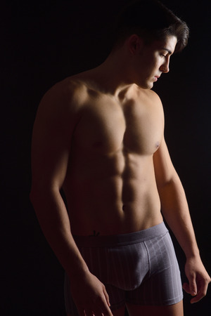 portrait of a man without clothes black backgroundの写真素材