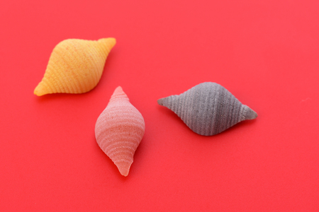 Pasta conchiglie on red backgroundの写真素材