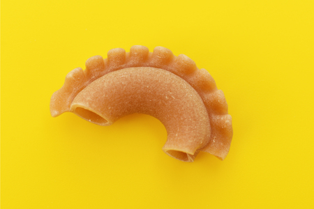 Pasta creste di gallo on yellow background