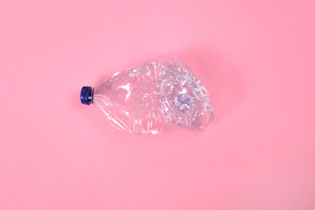 deformed plastic bottle on pink background
