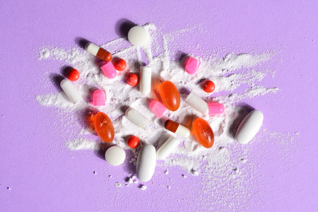 capsules pills broken with your powder medication on violet backgroundの写真素材