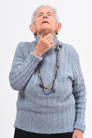 senior woman with pain in trachea white backgroundの写真素材