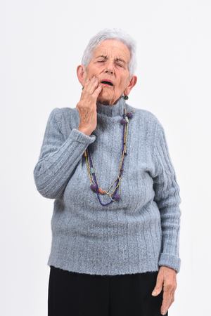 Senior woman with toothache on white backgroundの写真素材