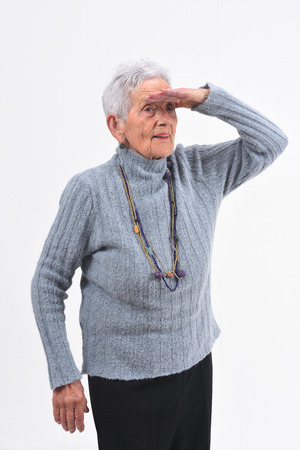 senior woman with hand in front looking away on white backgroundの写真素材