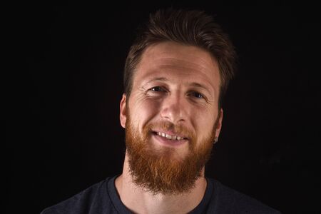 portrait of a man looking at camera on black background