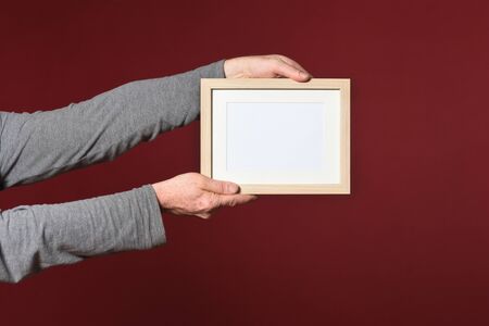 holding a frame of wood on red backgroundの写真素材