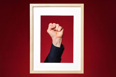 clenched fist in a frame and red backgroundの写真素材