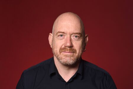 portrait of a bald man on red background