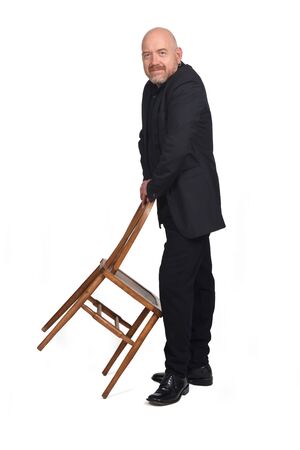 man in suit playing with a chair on white backgroundの写真素材