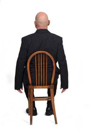 man sitting on a chair with her back on white background,の写真素材