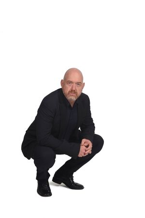 bald man squatting on white backgroundの写真素材