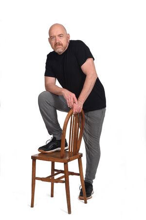 man standing with a chair in white backgroundの写真素材