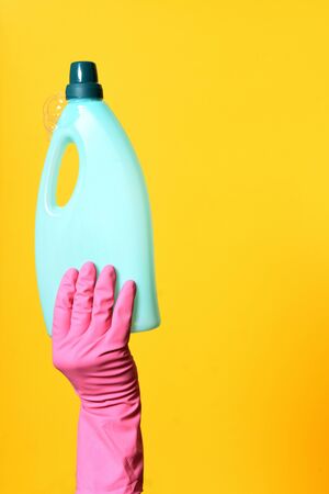 hand with gloves holding soap bottleの写真素材