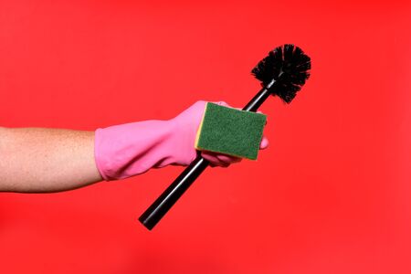 hand with glove, brush and pad on red background